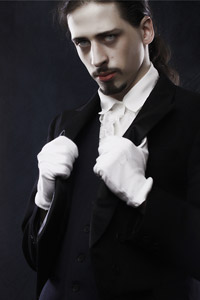 Бледнолицый вампир во фраке и белых перчатках.